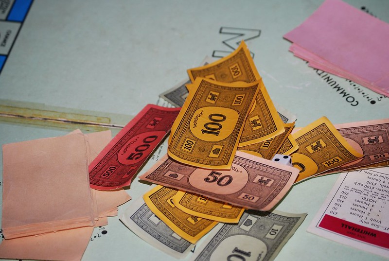 A monopoly game board with a pile of Monopoly money.