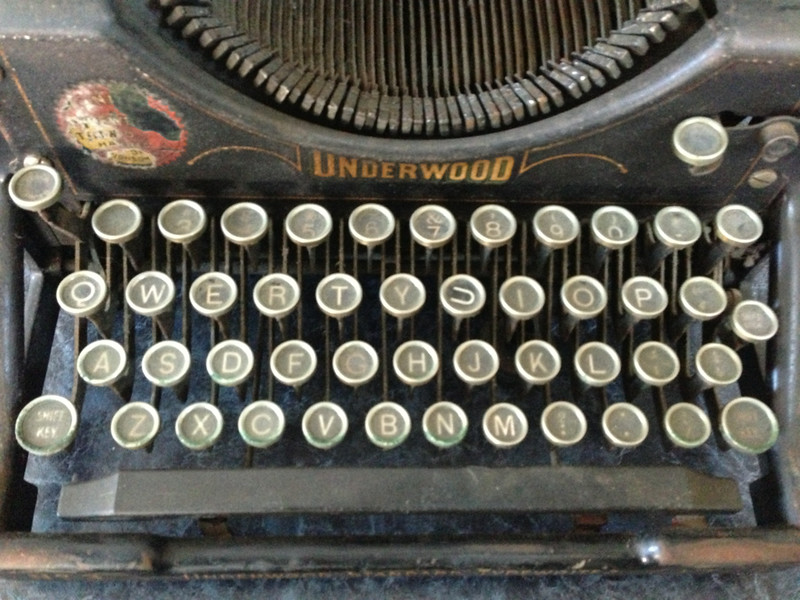 An antique typwriter with a focus on the keys. The u key is turned sideways.