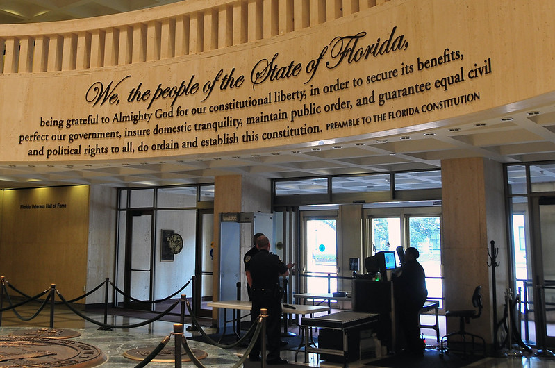 entrance to florida state capitol building shot from the interior with a wall-mounted quotation from the state's constitution