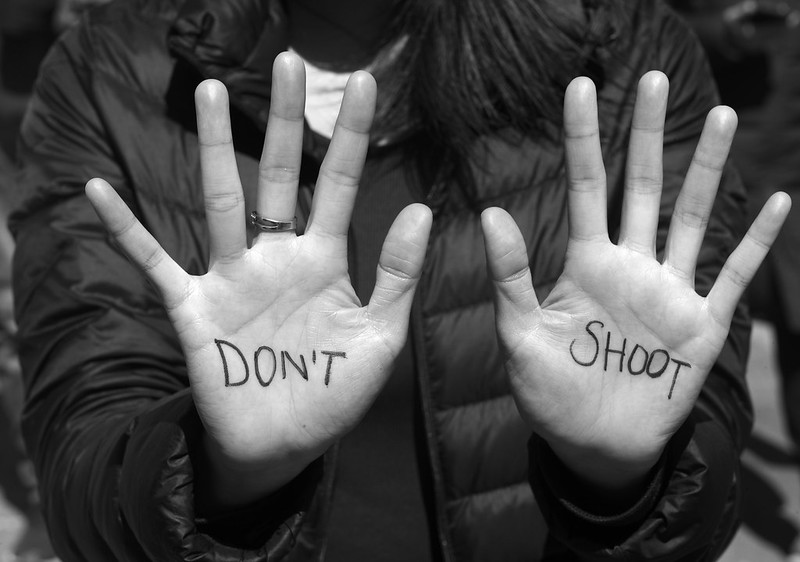 Hands, palms out, with the words "DON'T SHOOT"