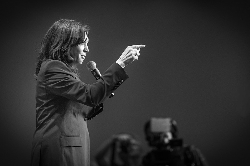 Black-and-white image of former U.S. Vice President Kamala Harris, pointing toward the unseen audience.